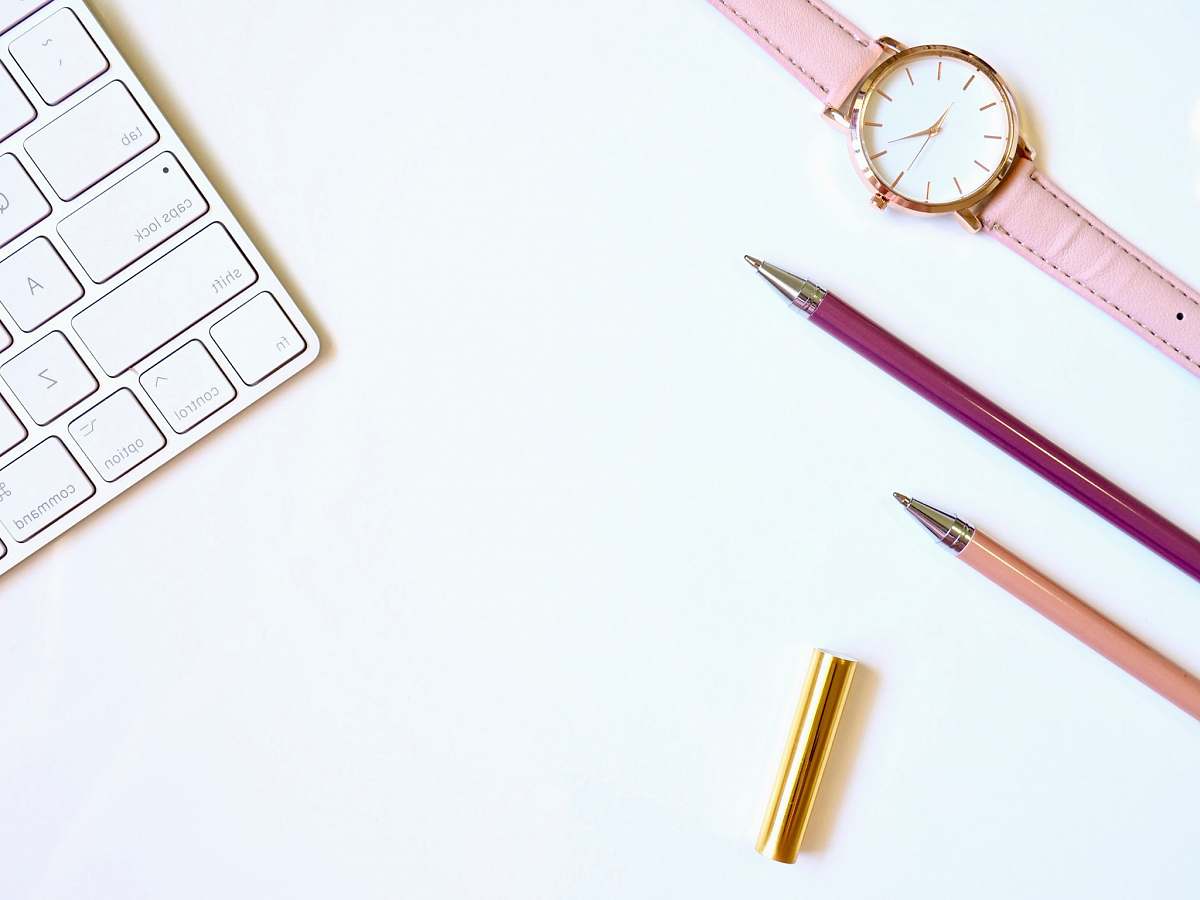 leisure activities pink pen on table with round gold-colored analog watch brass section